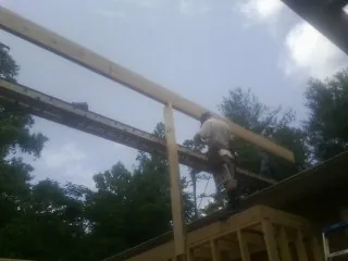 Carpenter setting a ridge beam over a new addition frame — Ice Dam Removal by Roofing Brothers in Zwingle