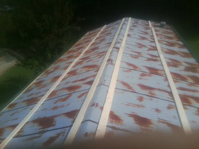 Rusted metal roof panels with new wood purlins before replacement — Storm Damage Roof Repair in Zwingle by Roofing Brothers