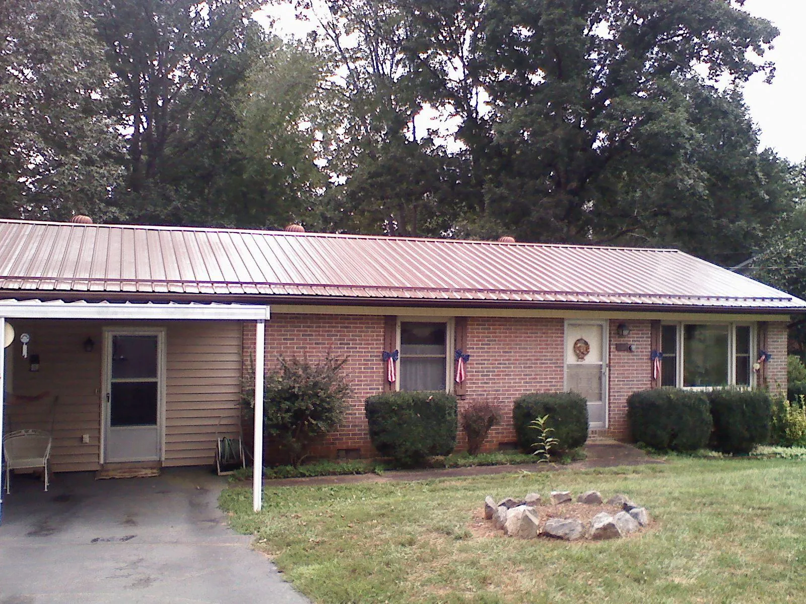 Bronze metal roof and carport on a brick ranch home — Roof Repair work by our crew in Zwingle